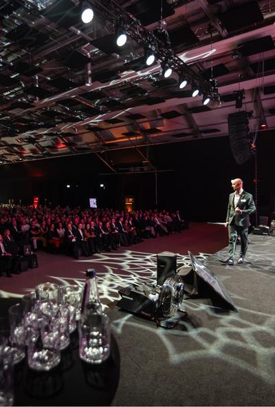 Prelegent na scenie, sala pełna uczestników, event rekrutacyjy