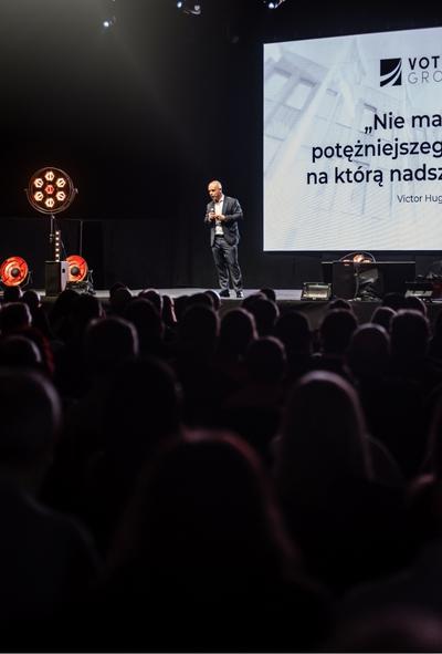 Zdjęcie przedstawia Bartłomieja Krupę w trakcie wystąpienia na evencie rekrutacyjnym